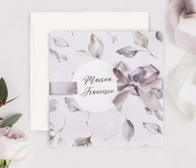 Invitación de boda hojas color morado con etiqueta personalizada en la portada y lazo en la gama de color