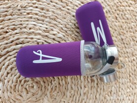 Botella de vidrio con neopreno con inicial del invitado grabada como detalle de boda, comunión, cumpleaños