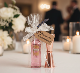 montaje del set del medidor y botellita de ginebra rosa decorada con lazada y etiqueta para los invitados de tu boda