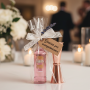 montaje del set del medidor y botellita de ginebra rosa decorada con lazada y etiqueta para los invitados de tu boda